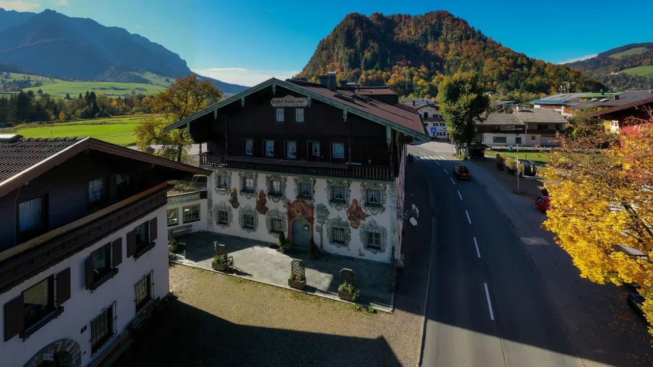 Hotel Walchseer Hof in Walchsee – Traditionelles Hotelgebäude mit Bergpanorama im Herbst | Wellnesshotel Tirol