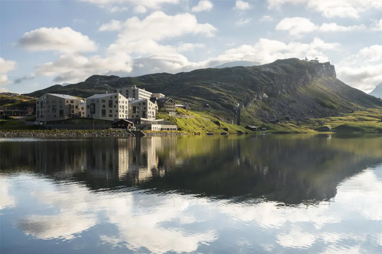 Frutt Mountain Resort in Kerns – Hotelgebäude am Bergsee mit Wolkenspiegelung | Wellnesshotel Zentralschweiz