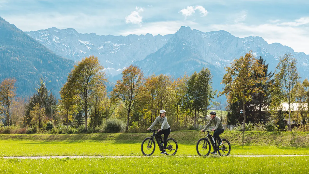 Das Walchsee Sportresort in Walchsee – Paar beim Radfahren vor beeindruckender Bergkulisse | Wellnesshotel Tirol