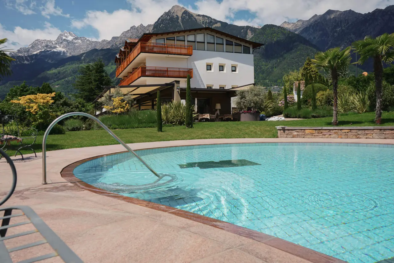 Breakfast Hotel Traubenheim in Meran – Außenpool mit Bergblick und Hotelgebäude | Wellnesshotel Südtirol