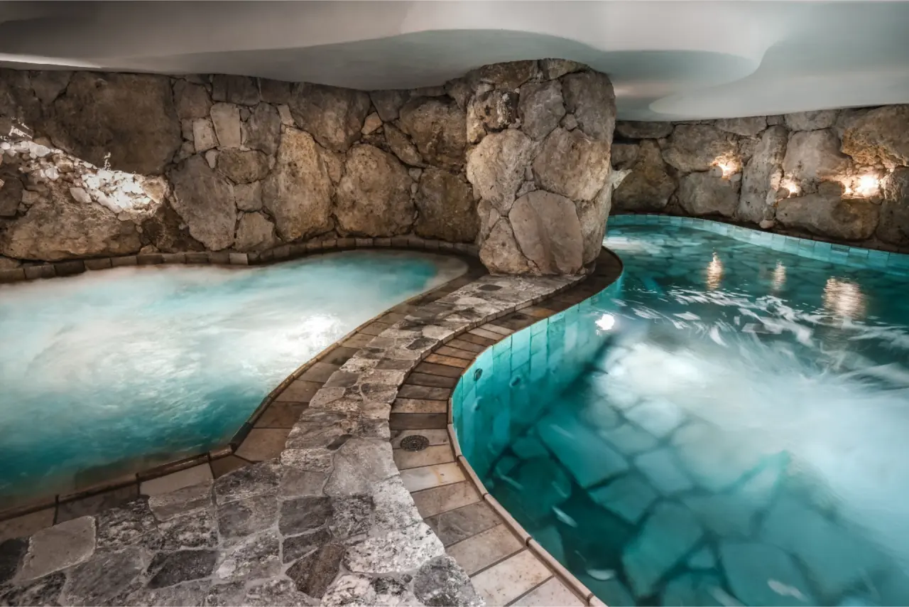 Hotel Corona in San Vigilio di Marebbe – Grotten-Whirlpool und Erlebnisbecken mit Steinwänden | Wellnesshotel Dolomiten