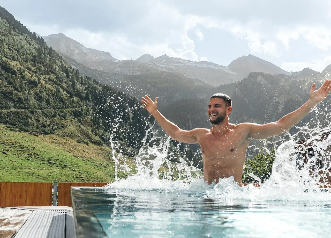 Hotel Klausnerhof in Hintertux – Strahlender Gast im Außenpool mit Zillertaler Alpenblick | Wellnesshotel Tirol