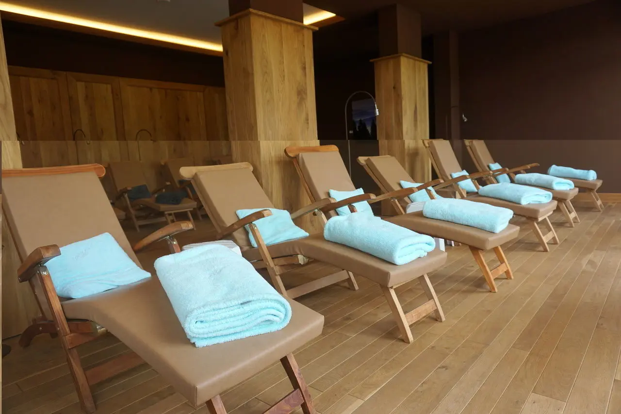 Hotel Rimberg in Schmallenberg – Entspannungsbereich mit Holzliegen und Handtüchern | Wellnesshotel Sauerland