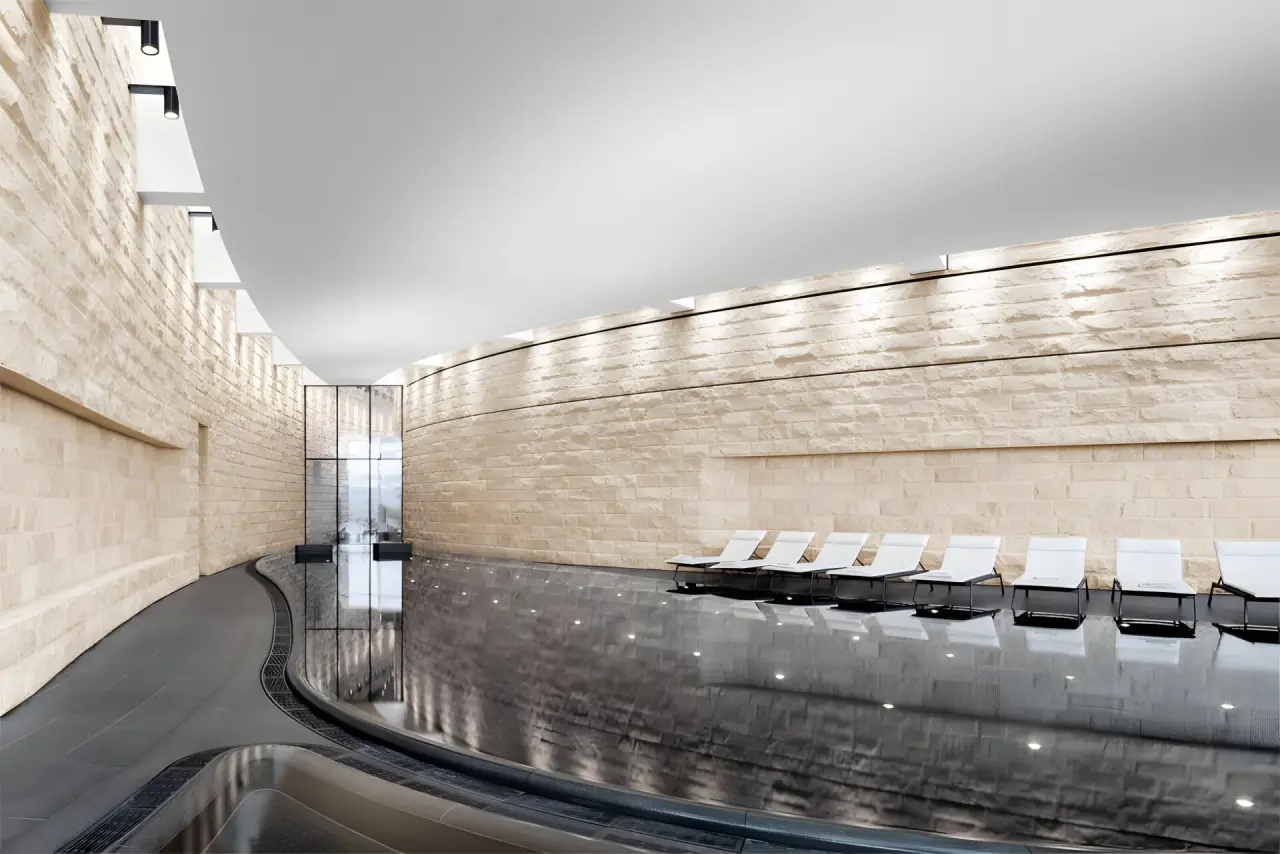 The Dolder Grand in Zürich – Moderner Innenpool mit Liegen und Steinwänden | Wellnesshotel Zürich