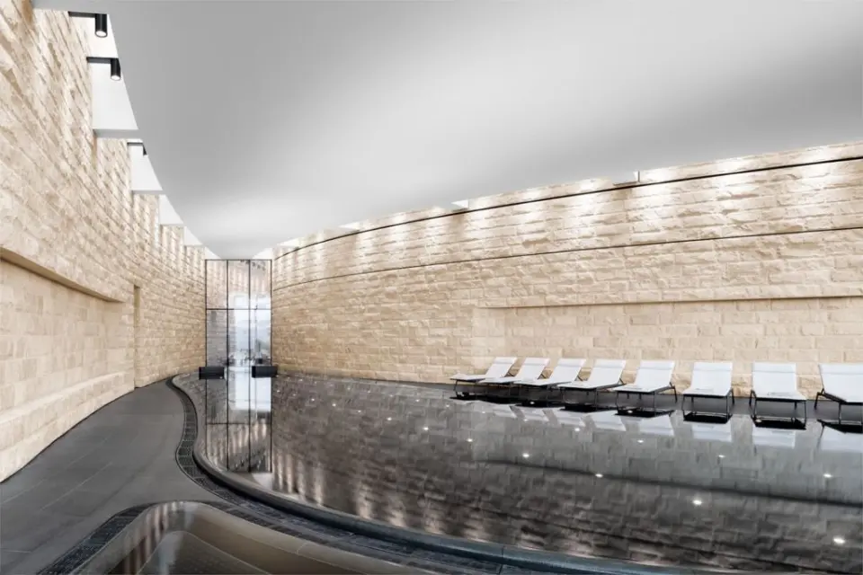 The Dolder Grand in Zürich – Moderner Innenpool mit Liegen und Steinwänden | Wellnesshotel Zürich