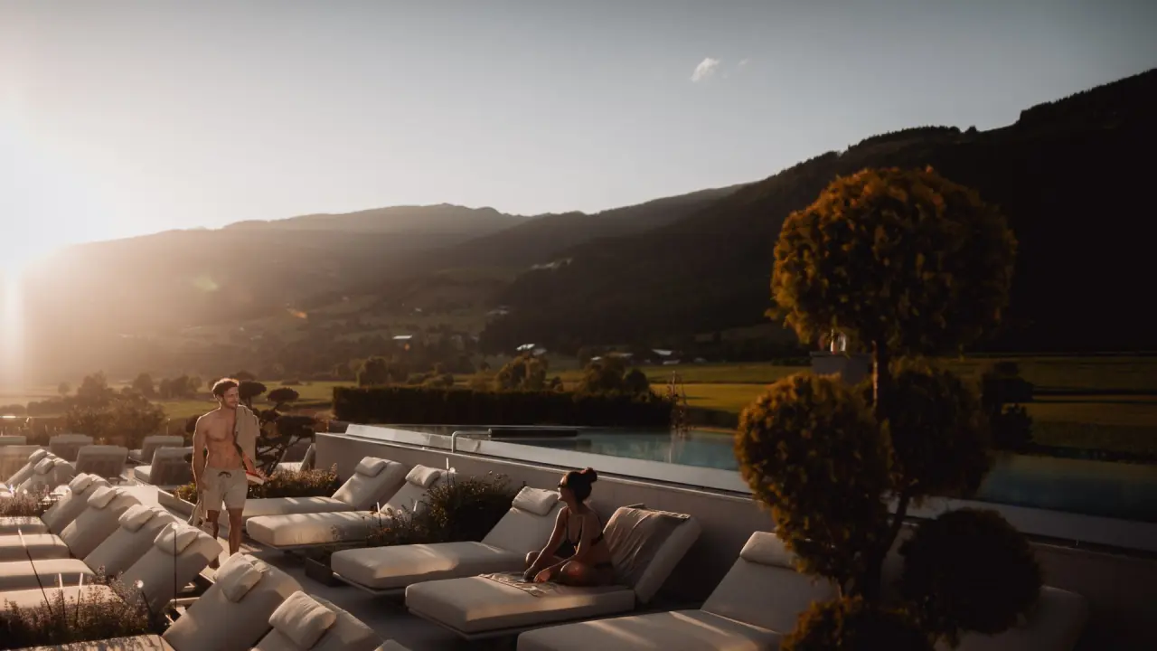 Hotel Winkler in St. Lorenzen – Entspannende Liegebereich am Pool mit Bergblick bei Sonnenuntergang | Wellnesshotel Südtirol