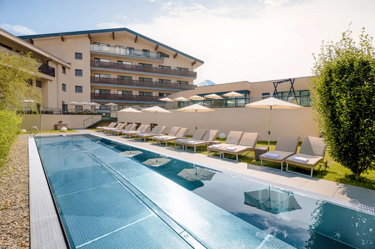 HAIDVOGL MAVIDA Zell am See in Zell am See – Außenpool mit Liegen und Hotelgebäude | Wellnesshotel Salzburger Land