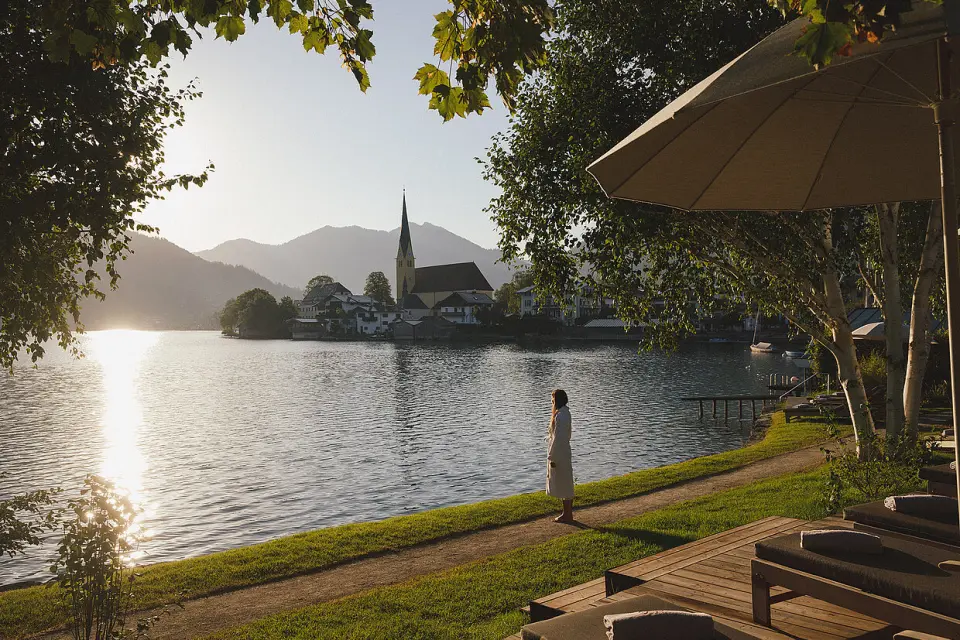 Althoff Seehotel Überfahrt in Rottach-Egern – Frau im Bademantel am Tegernsee mit Bergpanorama | Wellnesshotel Bayern
