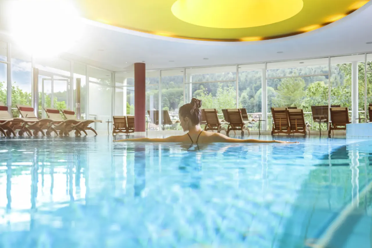 Schwarzwald Panorama in Bad Herrenalb – Helles Hallenbad mit entspannter Frau | Wellnesshotel Schwarzwald