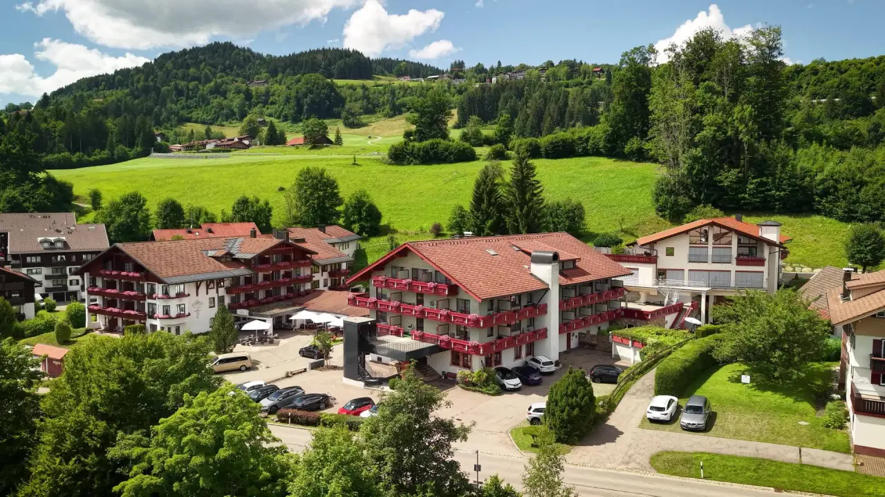 Königshof Hotel Resort in Oberstaufen – Außenansicht des Hotels im Grünen mit Bergen | Wellnesshotel Allgäu