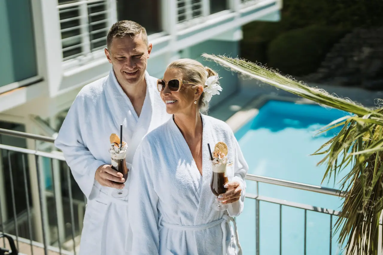 Kurhotel Sonnenhof in Bad Füssing – Paar in Bademänteln auf dem Balkon mit Poolblick | Wellnesshotel Bayern
