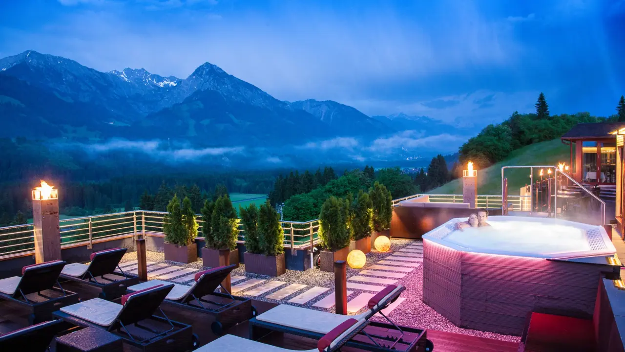 Allgäu Tanneck in Fischen im Allgäu – Outdoor-Whirlpool mit Bergblick bei Dämmerung | Wellnesshotel Allgäu