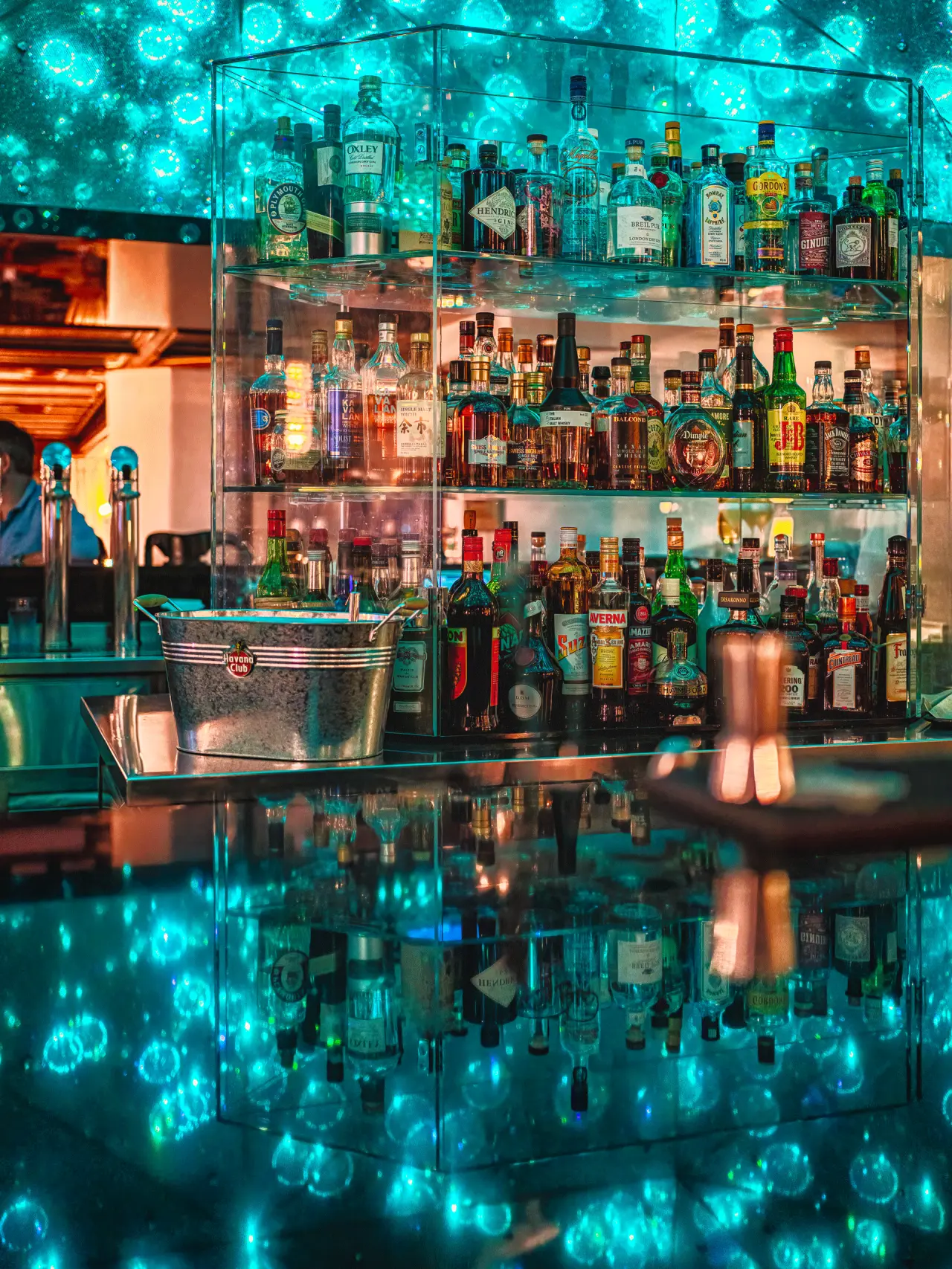 ERMITAGE Wellness- & Spa-Hotel in Gstaad – Moderne Hotelbar mit blauer Beleuchtung und großer Auswahl | Wellnesshotel Berner Oberland