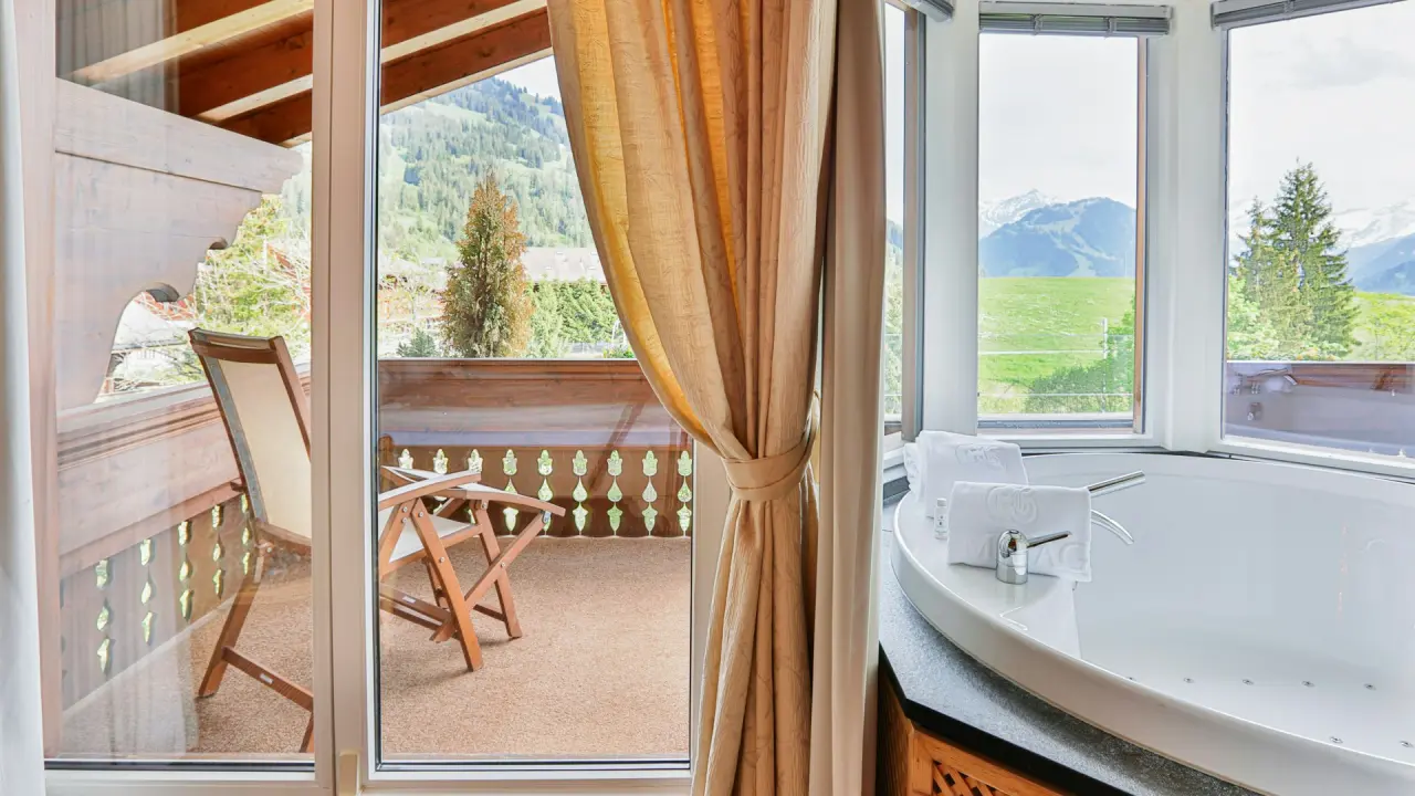 ERMITAGE Wellness- & Spa-Hotel in Gstaad – Badewanne mit Bergblick und Balkon | Wellnesshotel Berner Oberland
