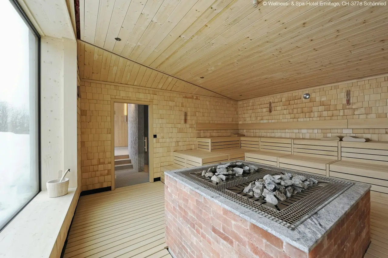 ERMITAGE Wellness- & Spa-Hotel in Gstaad – Geräumige Sauna mit Blick auf die Winterlandschaft | Wellnesshotel Berner Oberland