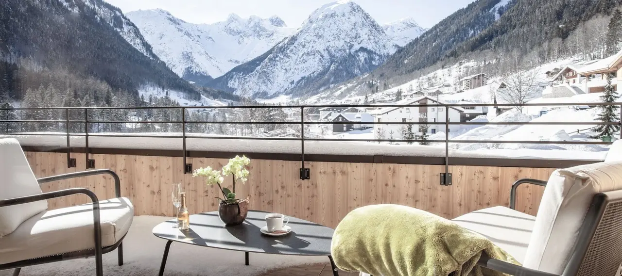 Alpenhotel Zimba in Brand – Balkon mit Sitzgelegenheiten und Panoramablick auf die verschneiten Berge | Wellnesshotel Brand