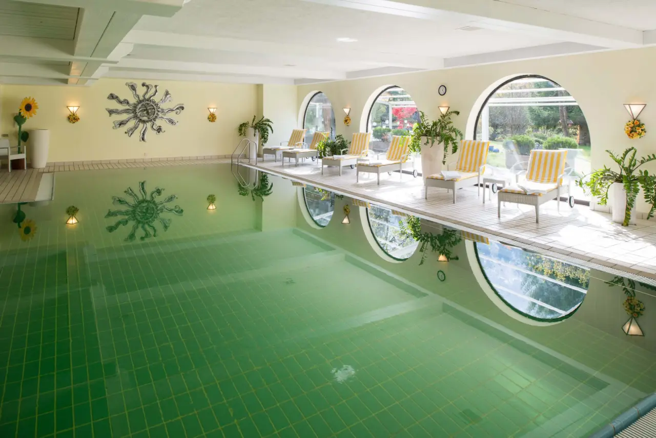 Hotel Alpenhof Grainau in Grainau – Heller Innenpool mit großen Rundfenstern und Liegebereich | Wellnesshotel Bayerische Alpen