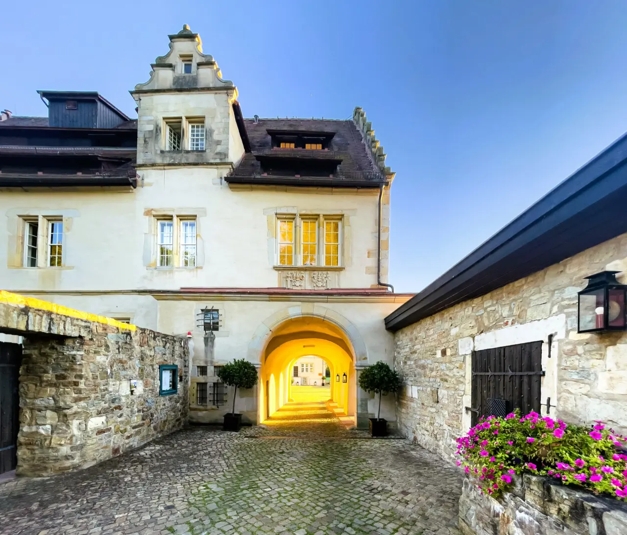 Schlosshotel Münchhausen in Aerzen – Historischer Torbogen des Schlosses bei Dämmerung | Wellnesshotel Weserbergland