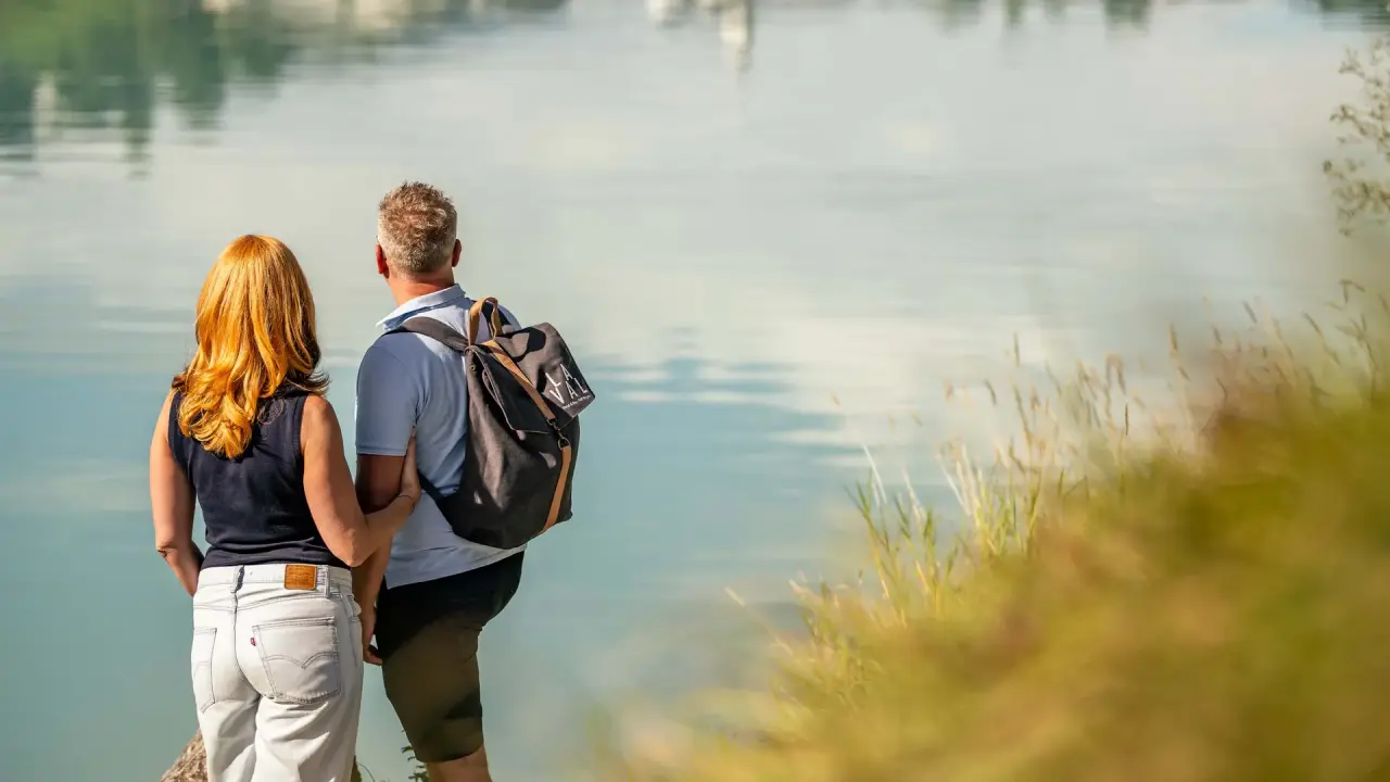 La Val Hotel & Spa in Brigels – Paar genießt die Aussicht auf einen See in der Natur | Wellnesshotel Graubünden
