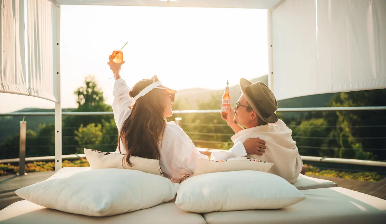 Thula Wellnesshotel Bayerischer Wald in Lalling – Paar entspannt auf Daybed im Freien mit Getränken | Wellnesshotel Bayern