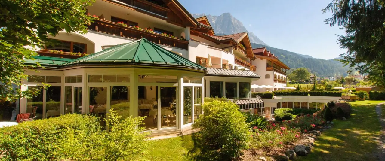 Hotel Alpen Residence in Ehrwald – Sommerliche Hotelansicht mit Garten und Bergpanorama | Wellnesshotel Tirol