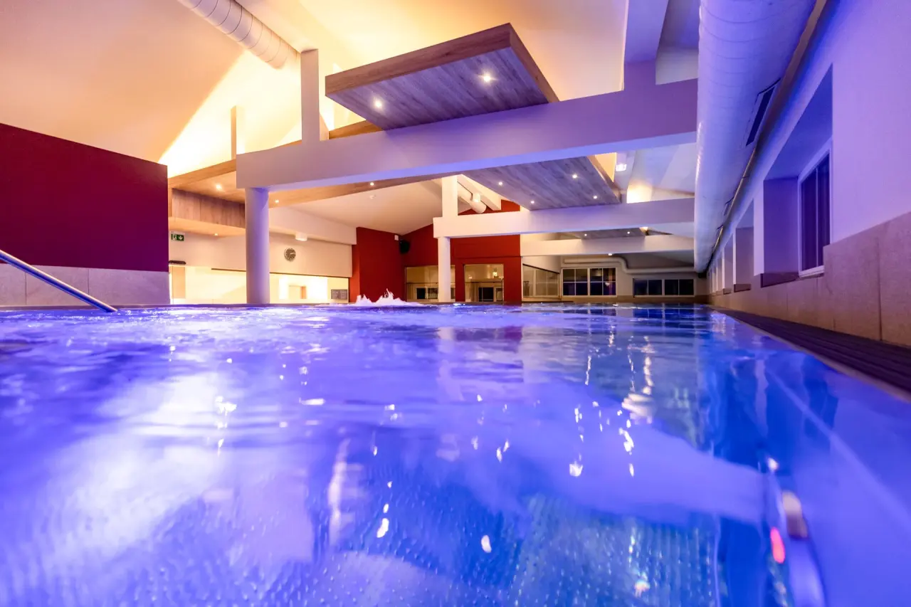 Galtenberg Resort 4*S in Alpbach – Modernes Hallenbad mit blauem Wasser und Design-Decke | Wellnesshotel Tirol