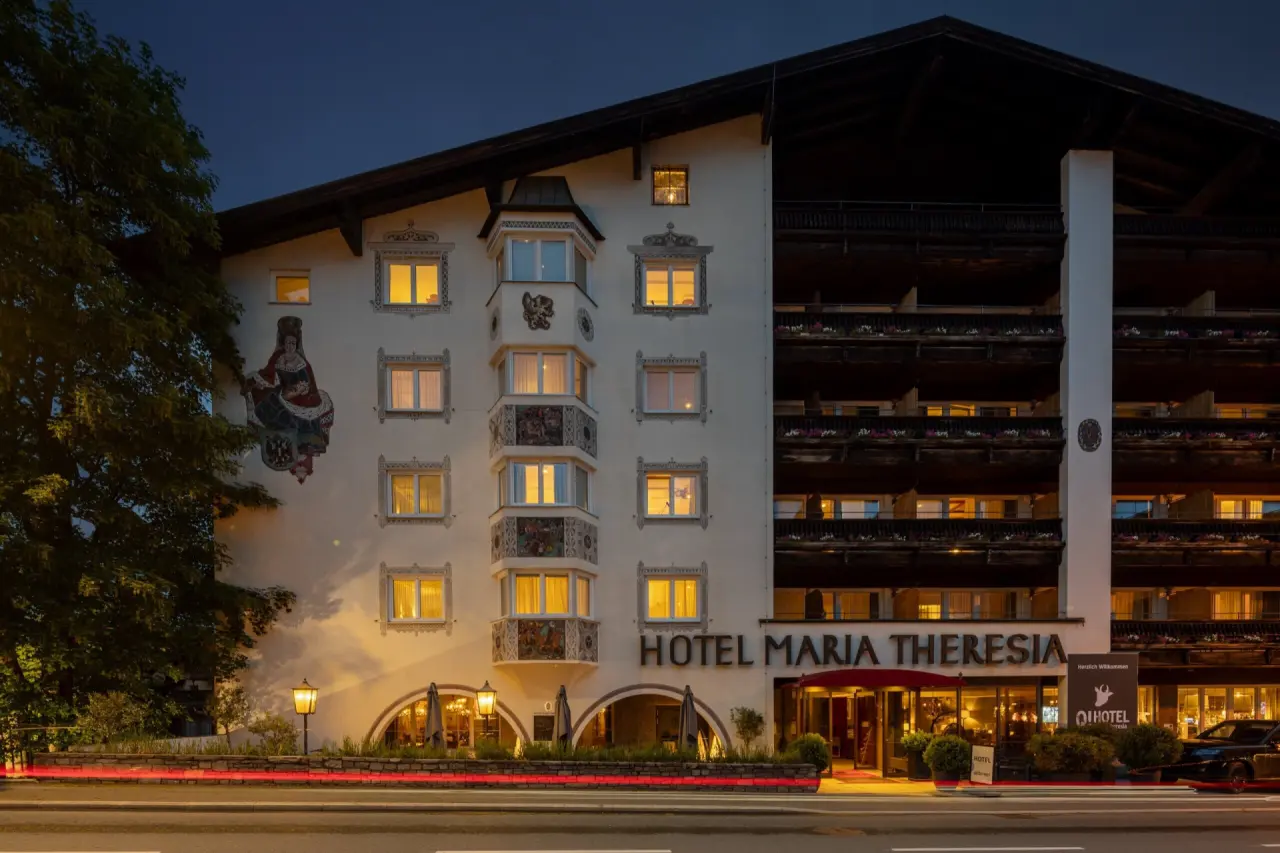 Q! Hotel Maria Theresia Kitzbühel in Kitzbühel – Beleuchteter Hoteleingang bei Nacht | Wellnesshotel Tirol