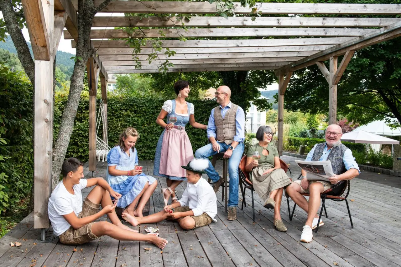 Bodenmaiser Hof in Bodenmais – Familie entspannt auf der Holzterrasse im Garten | Wellnesshotel Bayerischer Wald