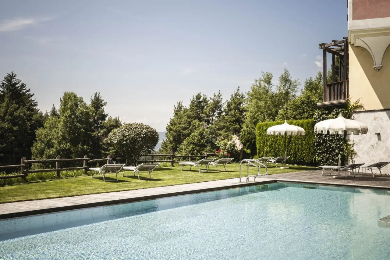Hotel Chalet Tianes in Kastelruth – Entspannungsbereich am Außenpool mit Sonnenliegen | Wellnesshotel Südtirol