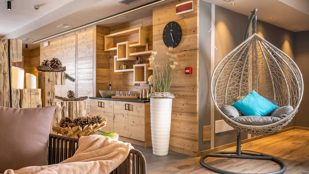 Césa Edelweiss Living & Spa Fassa in Campitello di Fassa – Entspannungsbereich mit Holzelementen und Hängesessel | Wellnesshotel Dolomiten