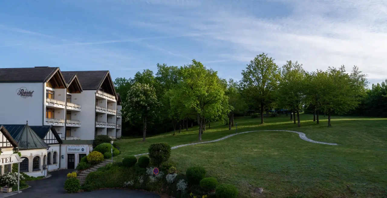 Reiterhof Bellevue Spa Resort Wirsberg in Wirsberg – Hotelgebäude umgeben von grüner Natur und Bäumen
