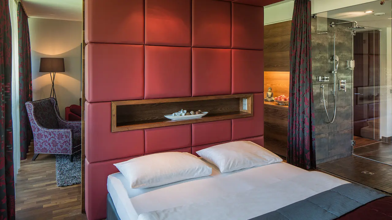 Asia Hotel & Spa Leoben in Leoben – Modernes Hotelzimmer mit rotem Kopfteil und offener Dusche | Wellnesshotel Steiermark