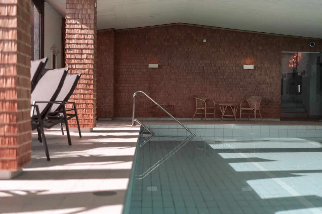 Mittelburg Wellnesshotel in Oy-Mittelberg – Heller Innenpoolbereich mit Liegestühlen und Holzverkleidung | Wellnesshotel Allgäu