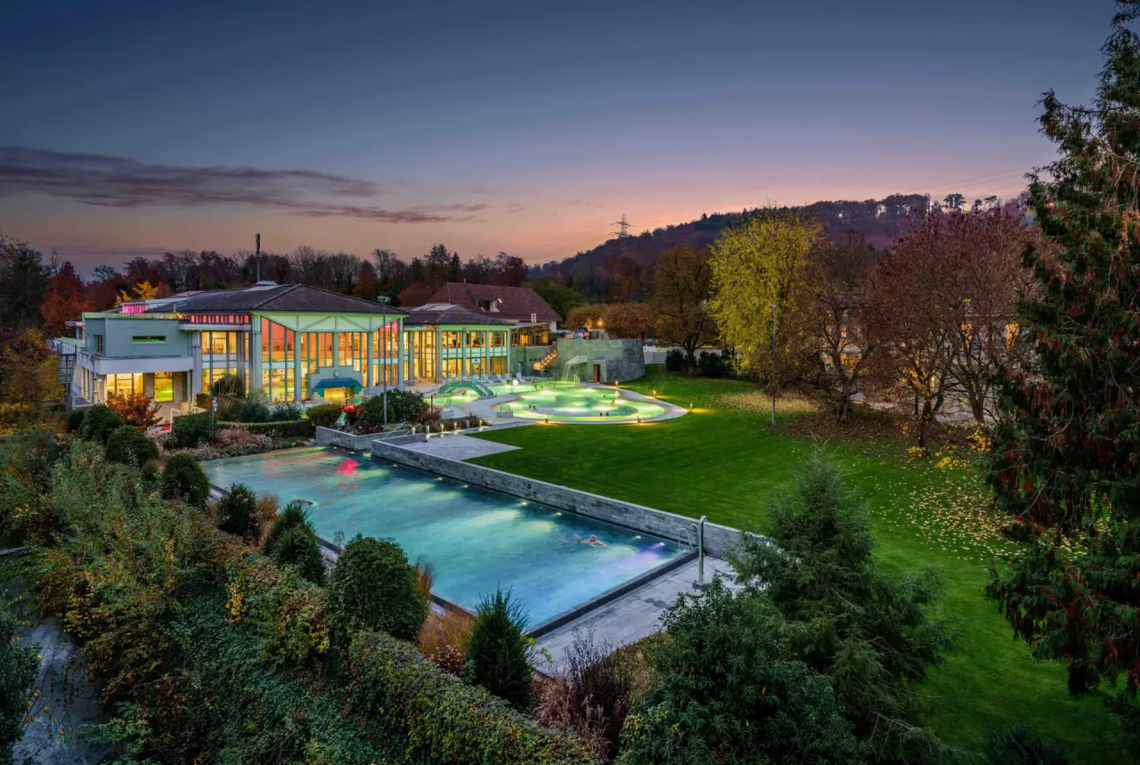 Kurhotel Im Park - Bad Schinznach in Baden – Beleuchtete Außenanlage mit Pools bei Dämmerung | Wellnesshotel Schweiz