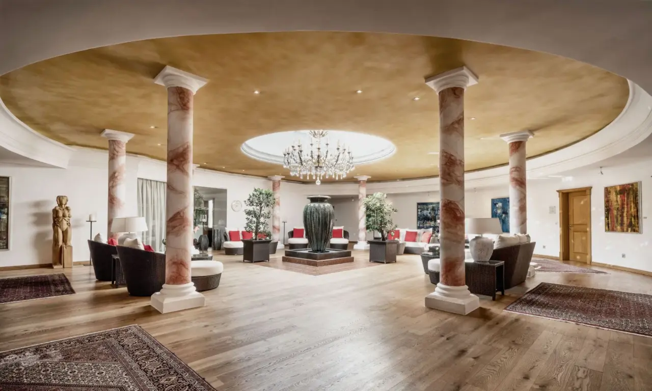 Burg Vital Resort in Lech am Arlberg – Beeindruckende Lobby mit Säulen und Kronleuchter | Wellnesshotel Arlberg