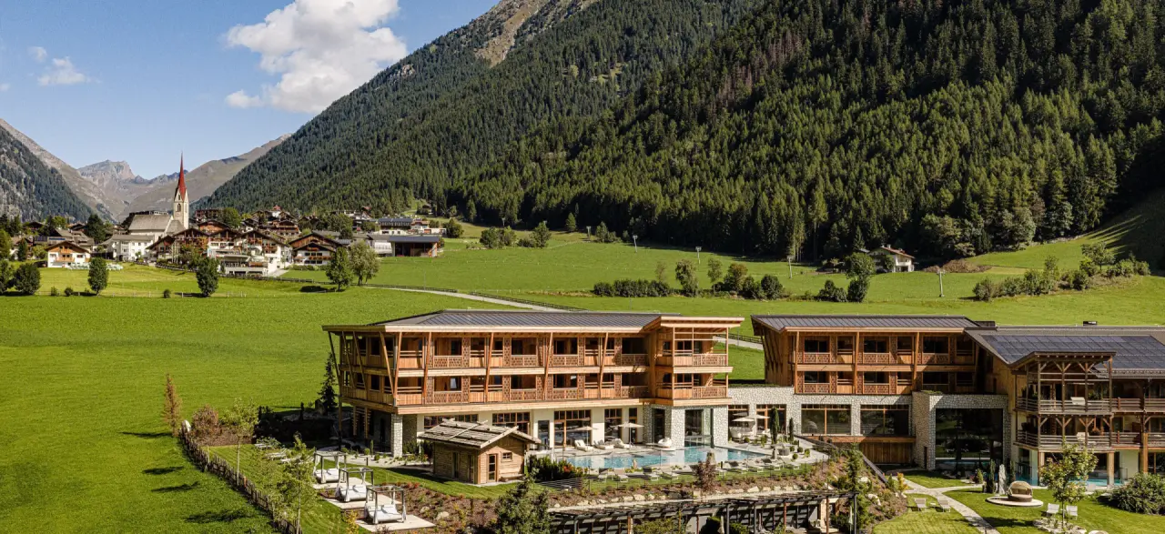 Hotel Masl in Vals (Mühlbach) – Panorama des Hotels mit Pool und Berglandschaft | Wellnesshotel Südtirol