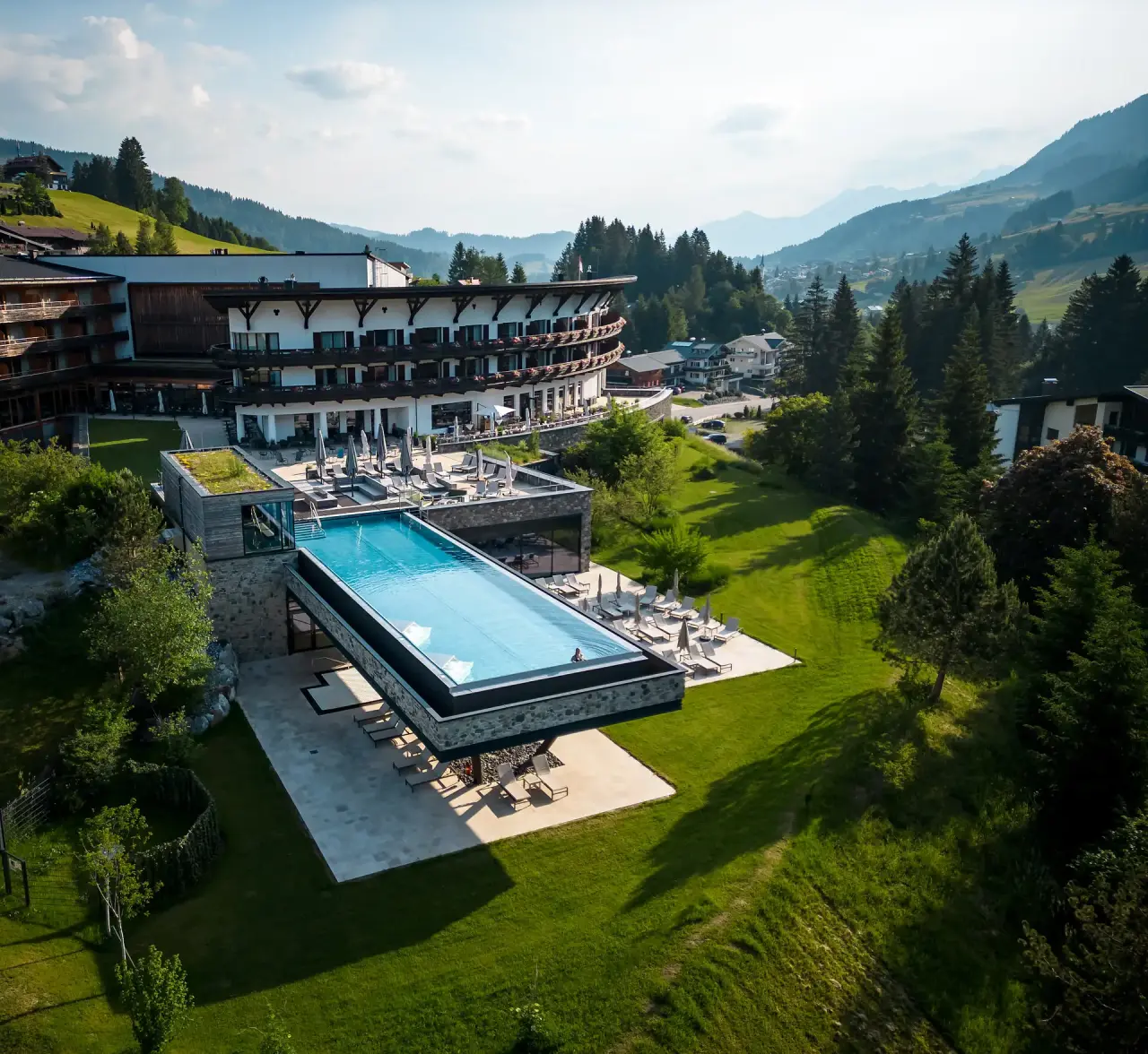 Travel Charme Ifen Hotel in Hirschegg – Hotelanlage mit Außenpool und grüner Landschaft | Wellnesshotel Kleinwalsertal