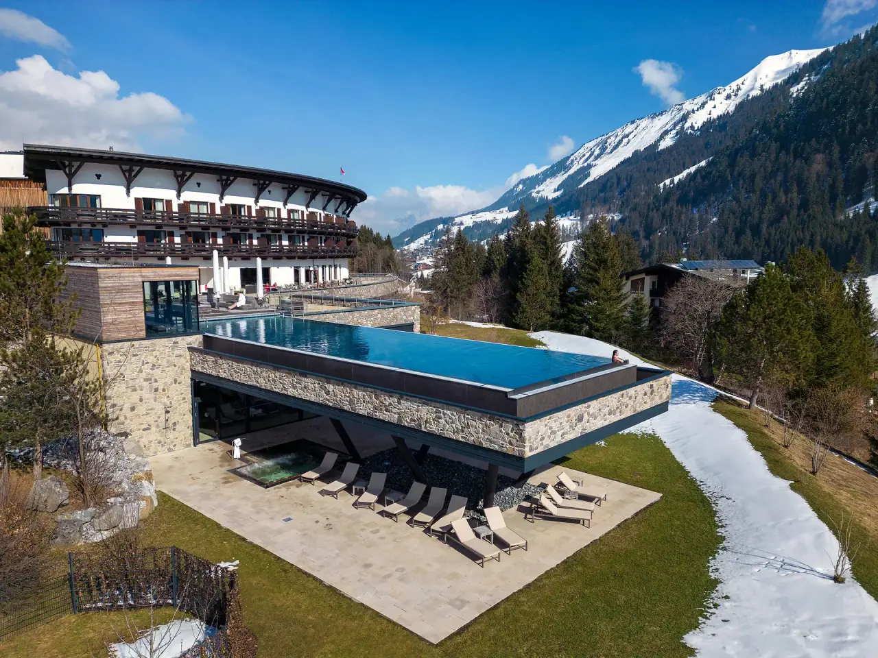 Travel Charme Ifen Hotel in Hirschegg – Hotelanlage mit Außenpool im Winter/Frühling | Wellnesshotel Kleinwalsertal