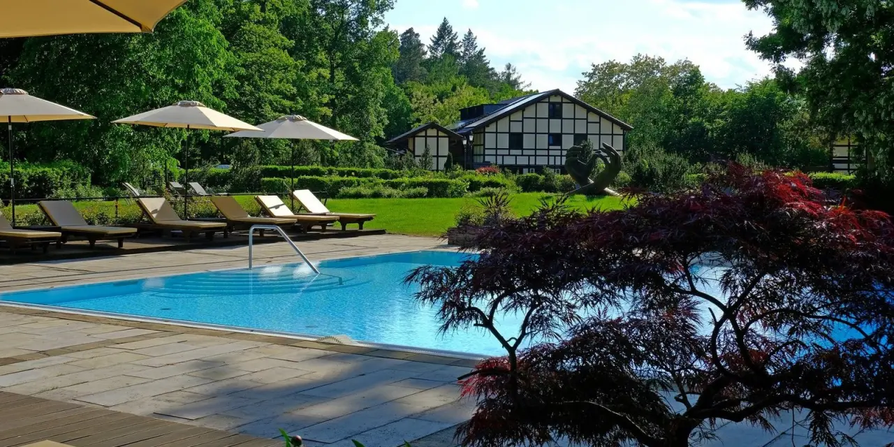 Gut Klostermühle Alt Madlitz in Briesen – Außenpool mit Liegen und Hotelgebäude | Wellnesshotel Brandenburg