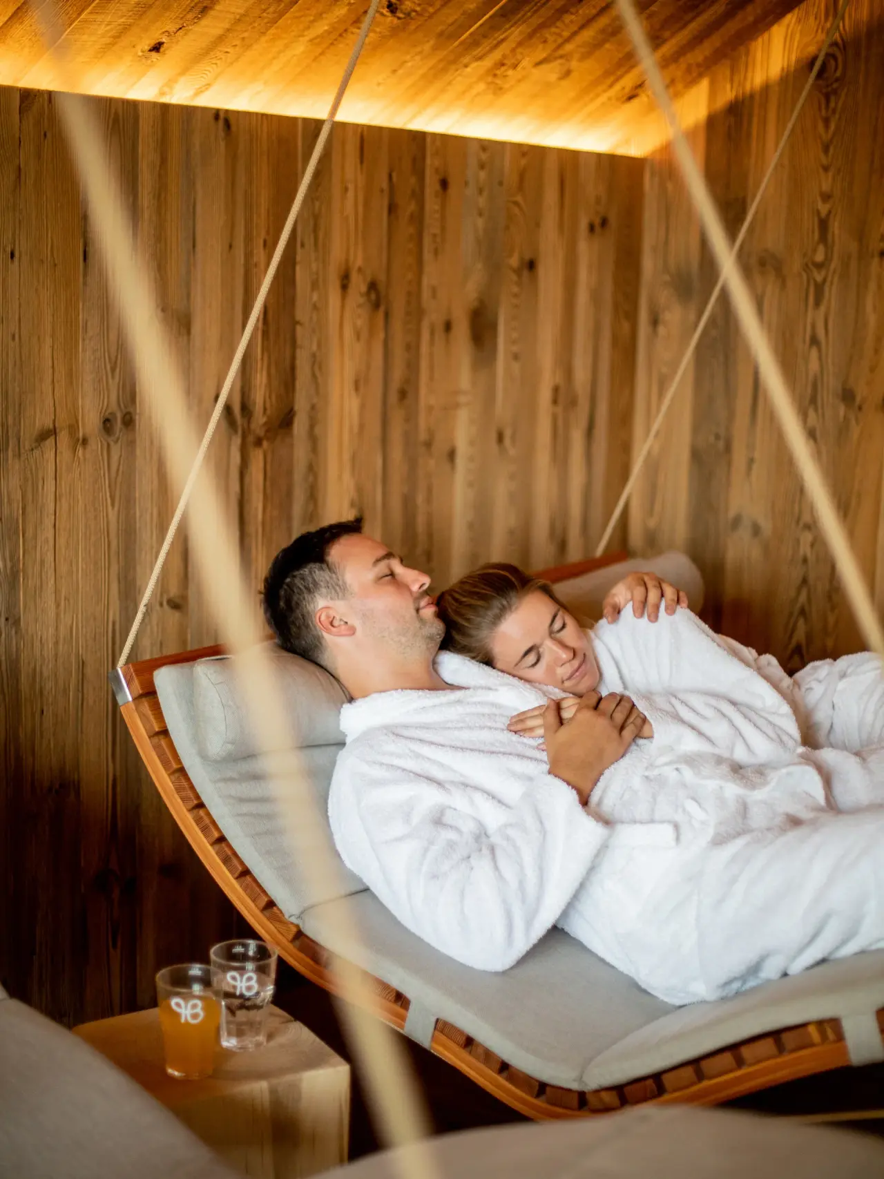 Pfalzblick Wald Spa Resort in Dahn – Paar entspannt in Bademänteln auf einer Schwebeliege | Wellnesshotel Pfalz