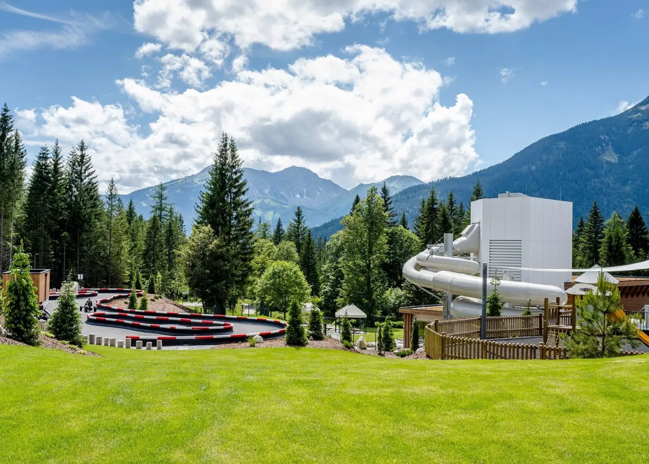 Zugspitz Resort in Ehrwald – Outdoor-Bereich mit Wasserrutsche und Go-Kart-Bahn vor Bergkulisse | Wellnesshotel Tirol