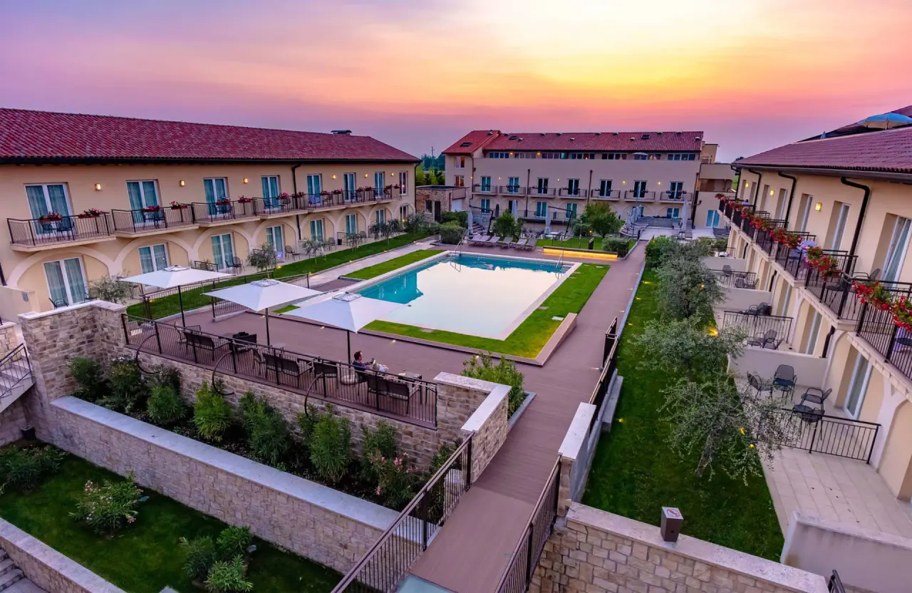 Hotel Leonardo in Lazise – Panoramablick auf Hotelanlage und Außenpool bei Abenddämmerung | Wellnesshotel Gardasee