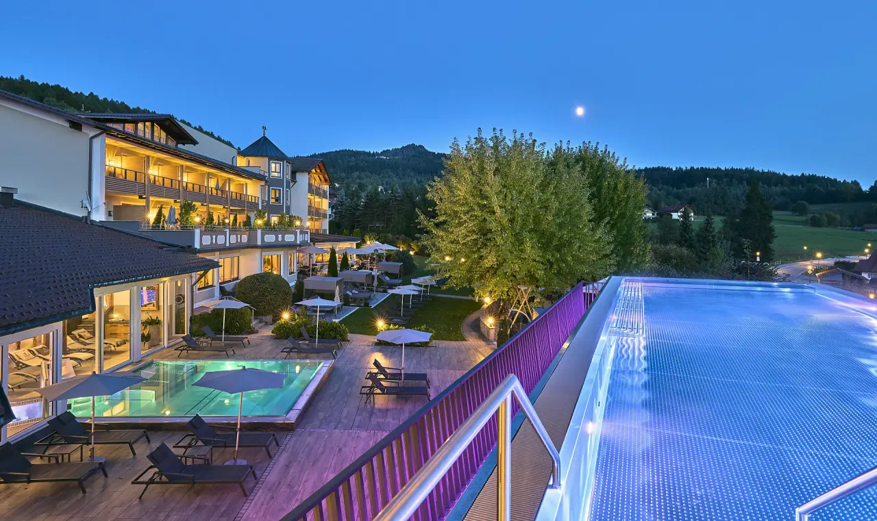 Kristall & Vitalhotel Bergknappenhof in Bodenmais – Beleuchteter Außenbereich mit Pools bei Nacht | Wellnesshotel Bayerischer Wald