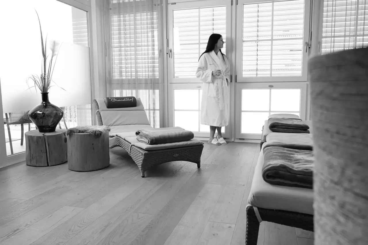 Landhotel Brandlhof in Röhrnbach – Entspannungsbereich mit Liegen und Gast im Bademantel | Wellnesshotel Bayerischer Wald