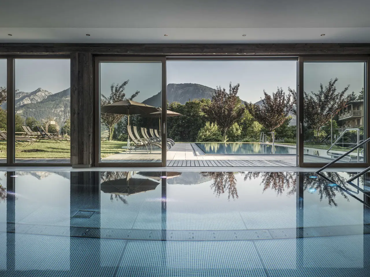 Bachmanngut in St. Wolfgang – Innenpool mit Blick auf Außenpool und Bergpanorama | Wellnesshotel Salzkammergut