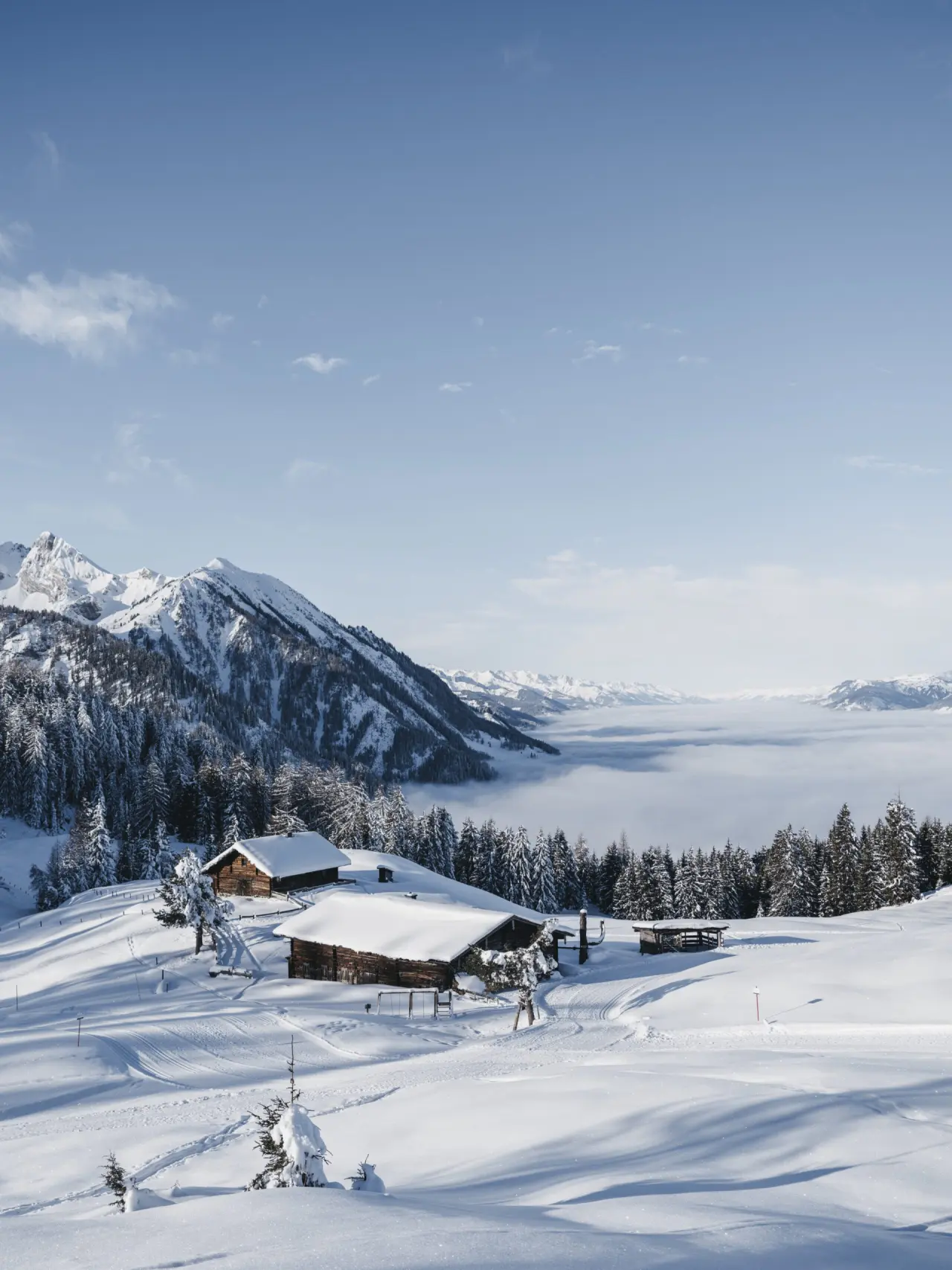 Sonnhof Alpendorf in St. Johann im Pongau – Winterliche Berglandschaft mit verschneiten Hütten | Wellnesshotel Salzburger Land