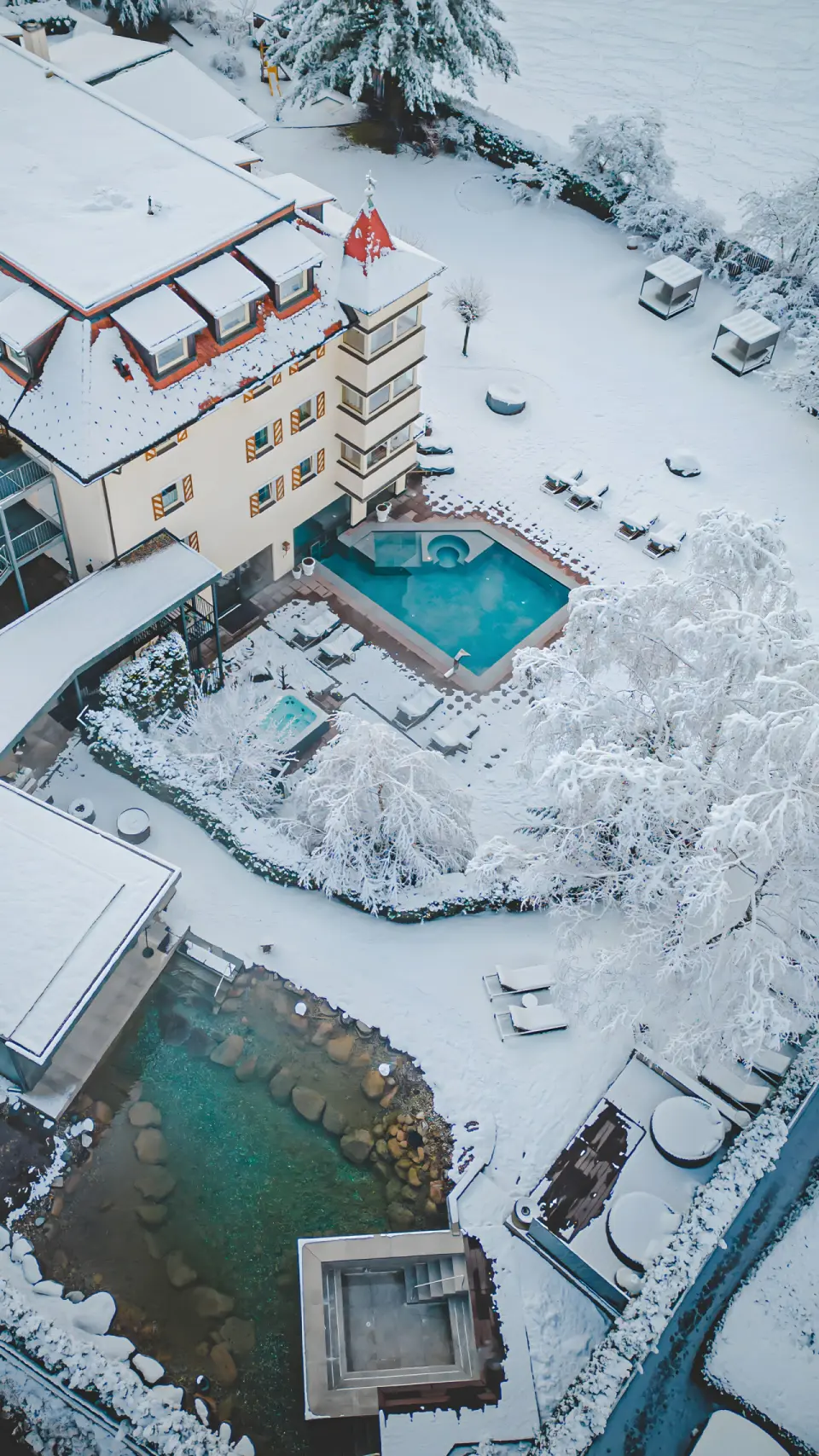 Majestic - Unique Spa Resort in Bruneck – Winterliche Außenansicht mit beheizten Pools | Wellnesshotel Südtirol