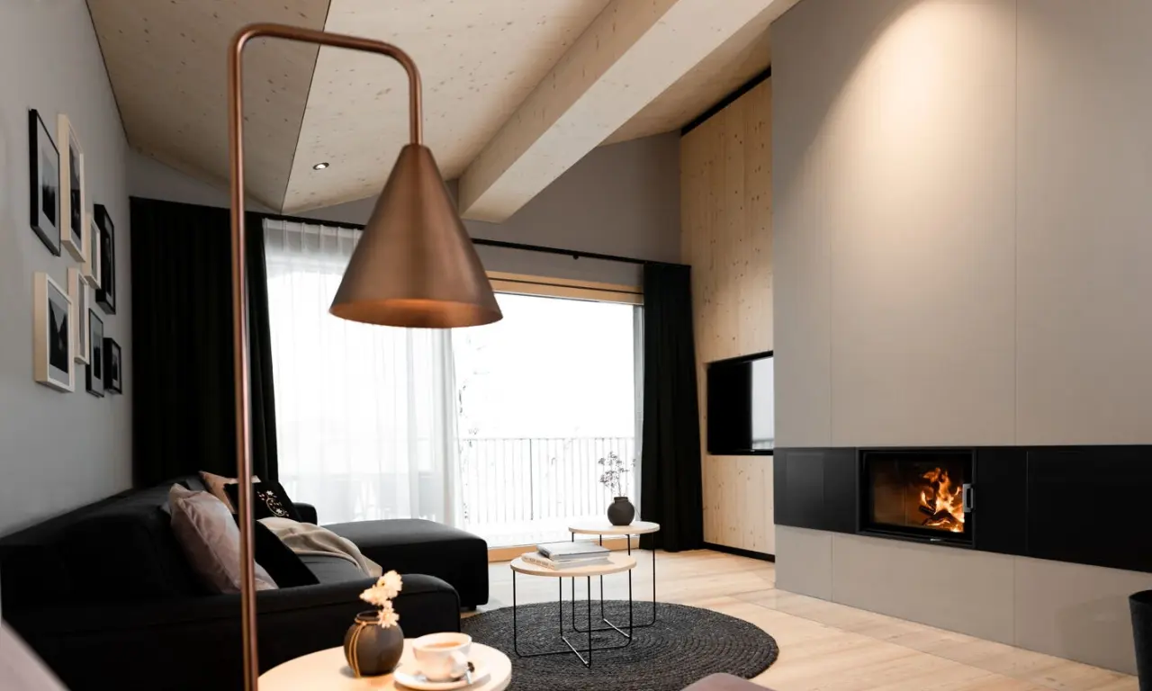 Amrai Suites in Schruns – Gemütliches Wohnzimmer einer Suite mit Kamin und Bergblick | Wellnesshotel Montafon