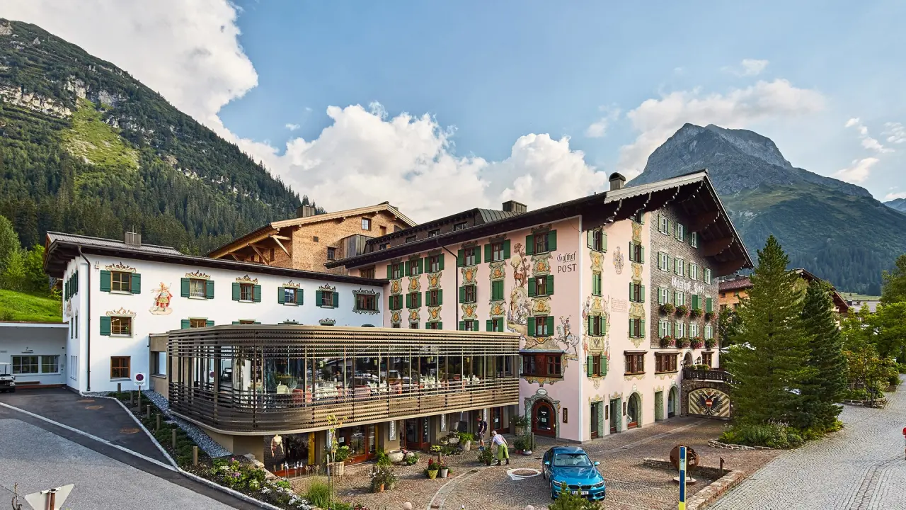 Hotel Post Lech in Lech am Arlberg – Traditionelles Hotelgebäude im Sommer mit Bergen | Wellnesshotel Arlberg