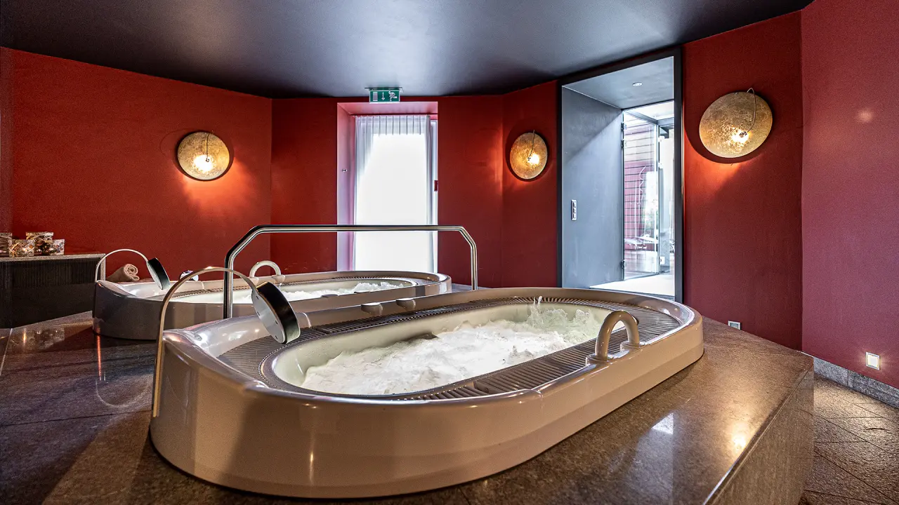 Hotel Belvédère in Scuol – Mineralbäder im Spa-Bereich mit warmem Licht | Wellnesshotel Graubünden